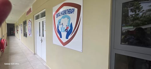 Interior hallway with pale yellow walls, white doors, and a red and blue shield logo on the wall